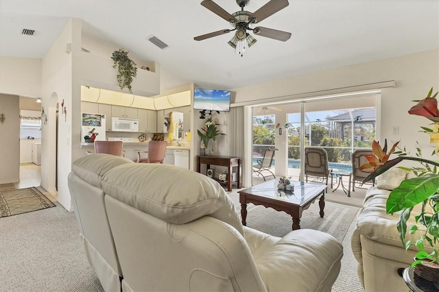 living room with lofted ceiling, light colored carpet, visible vents, and ceiling fan