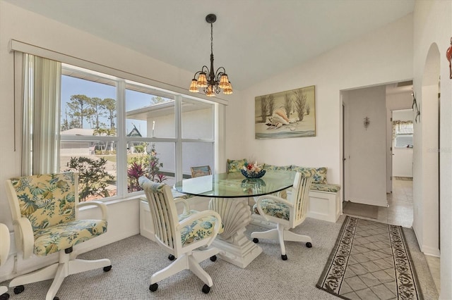 dining area with vaulted ceiling, a notable chandelier, and arched walkways