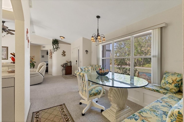 dining room with a notable chandelier, carpet, and vaulted ceiling