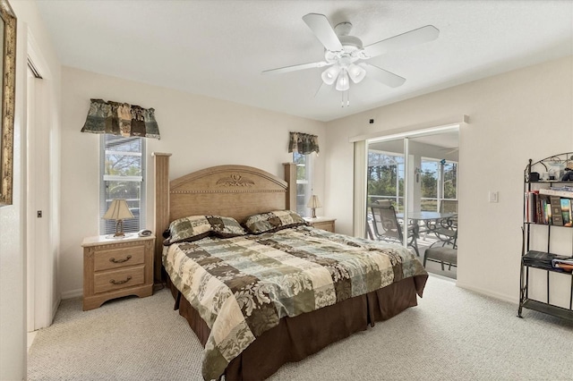 bedroom with multiple windows, light colored carpet, and access to outside