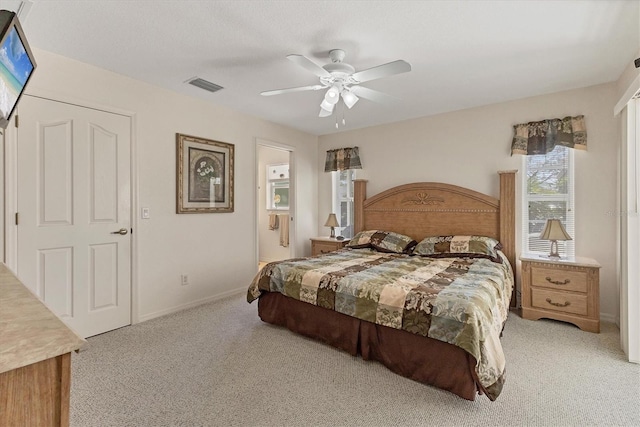 bedroom featuring a ceiling fan, baseboards, visible vents, light carpet, and connected bathroom