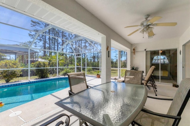 outdoor pool with a patio area, glass enclosure, outdoor dining area, and a ceiling fan