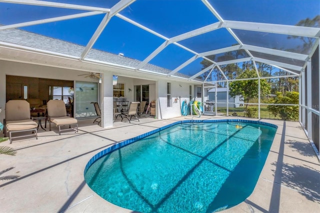 outdoor pool featuring a lanai, a patio area, and ceiling fan