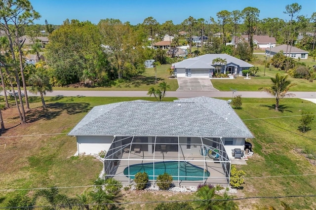 outdoor pool featuring a lanai, a lawn, and a patio