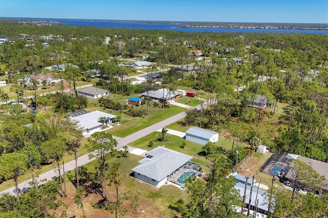 birds eye view of property featuring a residential view, a forest view, and a water view