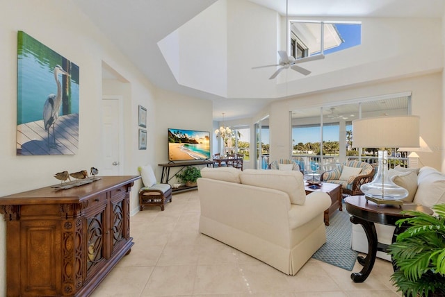 living area featuring light tile patterned flooring, ceiling fan with notable chandelier, and high vaulted ceiling