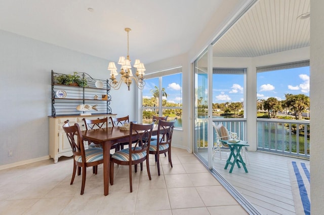 dining space with light tile patterned floors, baseboards, and a chandelier