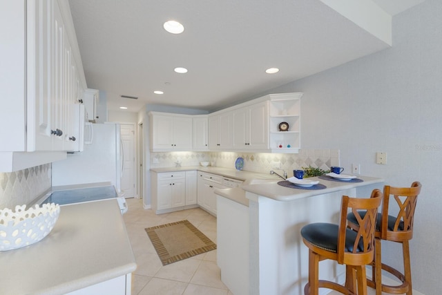 kitchen featuring decorative backsplash, a peninsula, a kitchen breakfast bar, light tile patterned flooring, and open shelves