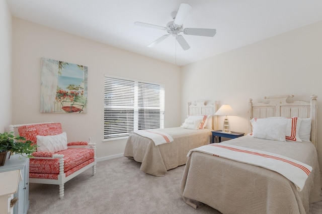 bedroom featuring baseboards, light colored carpet, and ceiling fan