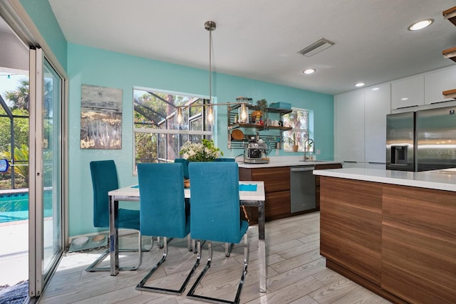 kitchen featuring visible vents, light wood finished floors, light countertops, appliances with stainless steel finishes, and modern cabinets