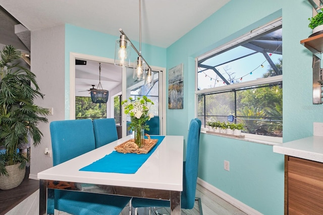 dining area with a ceiling fan, wood finished floors, baseboards, and a sunroom