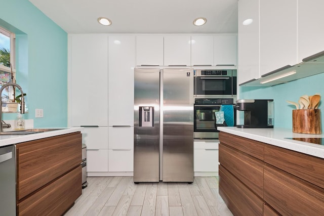 kitchen featuring white cabinetry, modern cabinets, appliances with stainless steel finishes, and a sink