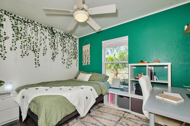 bedroom with a ceiling fan and a textured wall