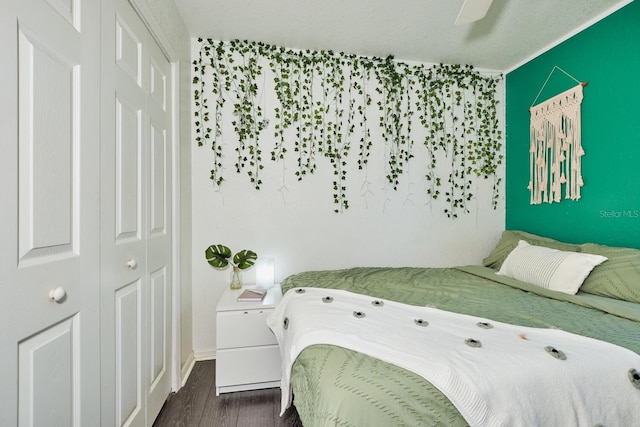 bedroom with a closet, dark wood finished floors, baseboards, and a ceiling fan