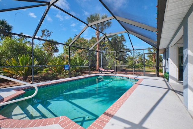 pool featuring glass enclosure and a patio area