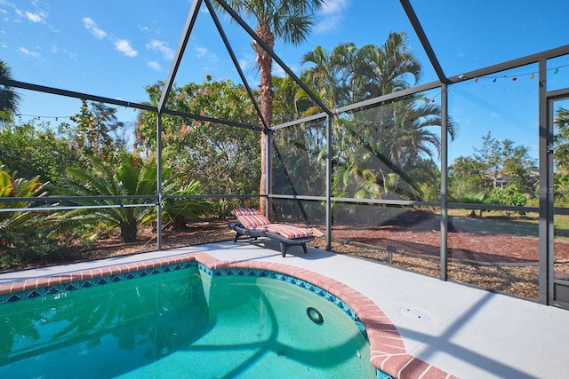 outdoor pool with glass enclosure and a patio