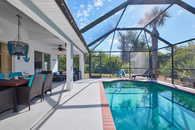 pool with a patio area, glass enclosure, and ceiling fan