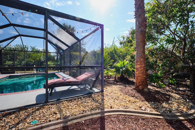 outdoor pool with glass enclosure and a patio