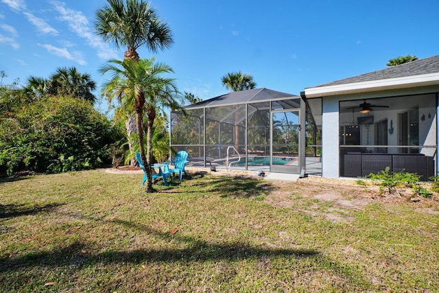 view of yard with glass enclosure and an outdoor pool