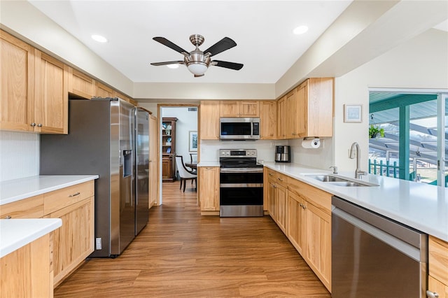 kitchen featuring a sink, ceiling fan, light brown cabinetry, stainless steel appliances, and light wood-type flooring