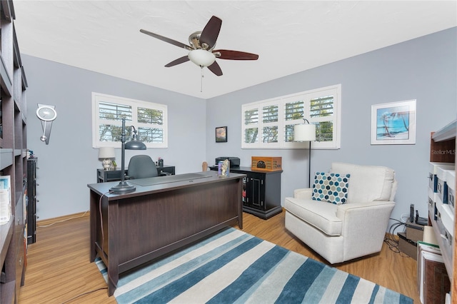 office space with light wood-type flooring and a ceiling fan