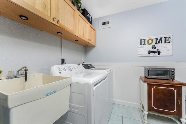 laundry room featuring visible vents, independent washer and dryer, a sink, cabinet space, and light tile patterned floors