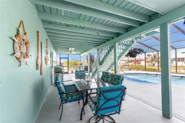 view of patio / terrace with glass enclosure, stairway, and an outdoor pool