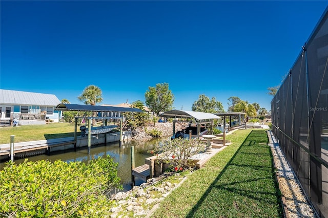 view of dock featuring a lanai, a yard, and a water view