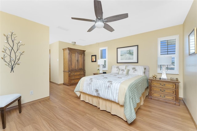 bedroom with a ceiling fan, light wood-style floors, and baseboards