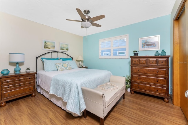 bedroom with light wood-style flooring, a ceiling fan, and a closet