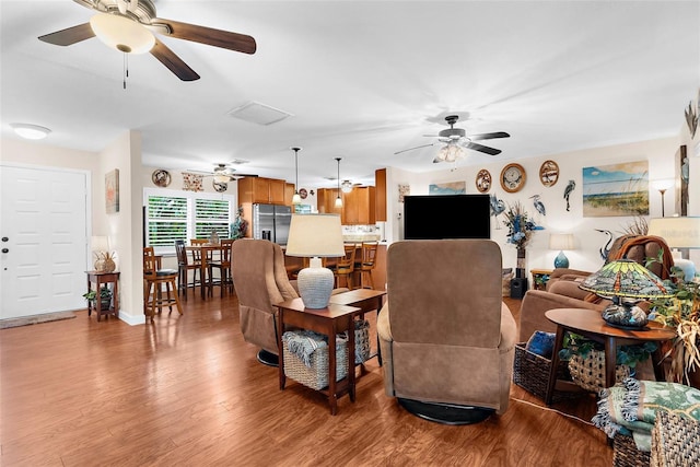 living room with wood finished floors and a ceiling fan