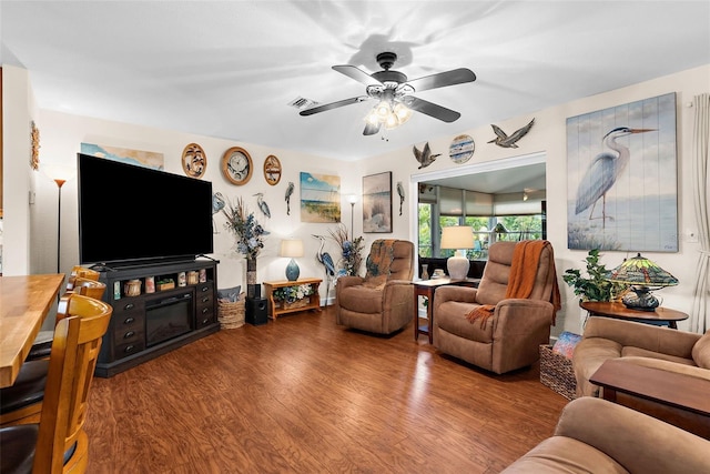 living area with ceiling fan, visible vents, and wood finished floors