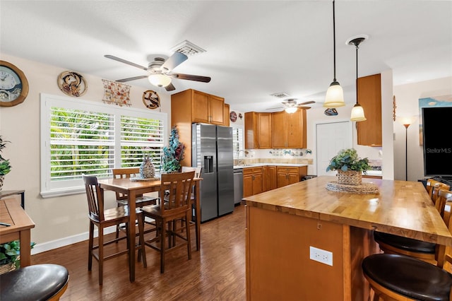 kitchen featuring dark wood-type flooring, butcher block countertops, a ceiling fan, and stainless steel appliances