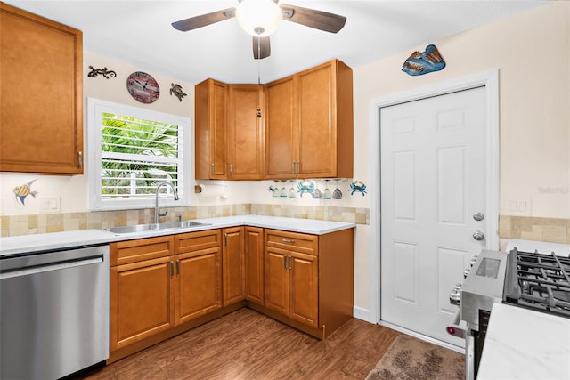 kitchen with ceiling fan, light countertops, wood finished floors, stainless steel appliances, and a sink