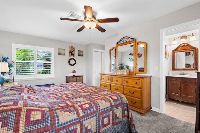 bedroom featuring visible vents, a sink, a closet, connected bathroom, and light colored carpet