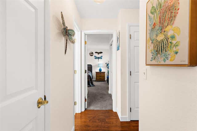 corridor with baseboards and dark wood-style flooring