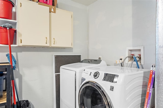 washroom featuring cabinet space and washer and clothes dryer