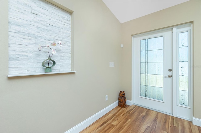 doorway with wood finished floors, baseboards, and a wealth of natural light