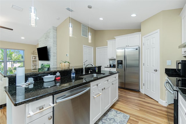 kitchen with visible vents, a sink, vaulted ceiling, appliances with stainless steel finishes, and light wood-type flooring