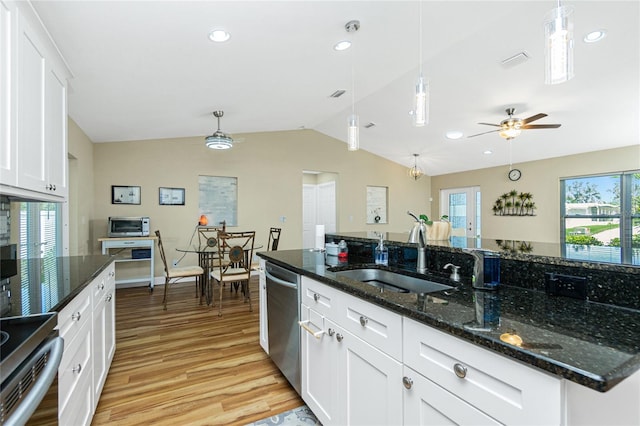 kitchen with visible vents, a sink, vaulted ceiling, light wood-style floors, and stainless steel dishwasher