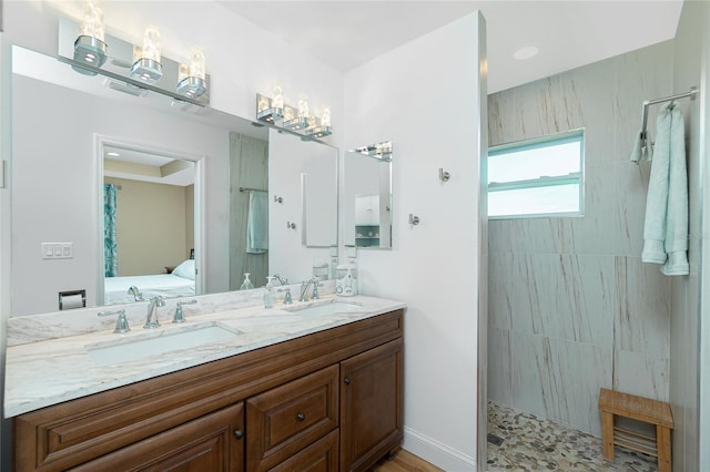 ensuite bathroom featuring double vanity, a walk in shower, ensuite bathroom, and a sink