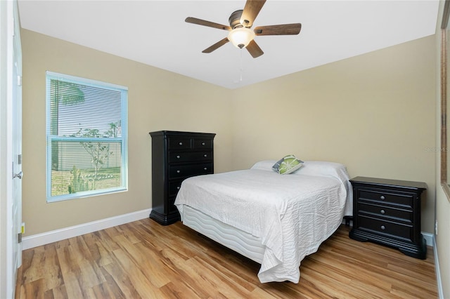 bedroom featuring a ceiling fan, baseboards, and light wood-type flooring