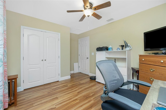 office area featuring light wood finished floors, visible vents, a ceiling fan, and baseboards