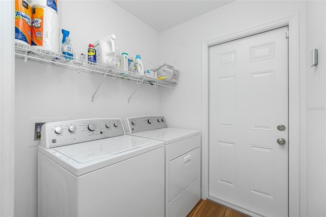 clothes washing area with laundry area, light wood-style flooring, and washer and clothes dryer