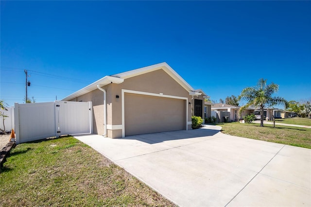 single story home featuring stucco siding, a front lawn, driveway, a gate, and a garage