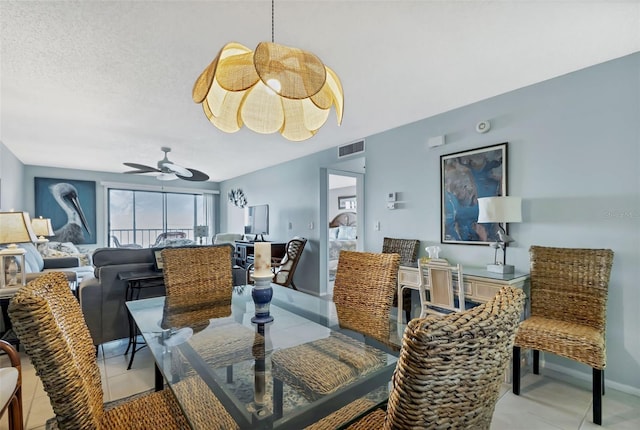 dining room featuring visible vents, a ceiling fan, a textured ceiling, light tile patterned floors, and baseboards