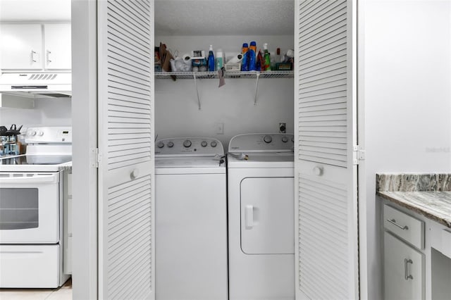 laundry room with a textured ceiling, washing machine and dryer, and laundry area