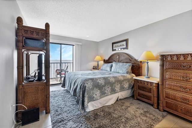 bedroom featuring a textured ceiling, light tile patterned flooring, and access to outside