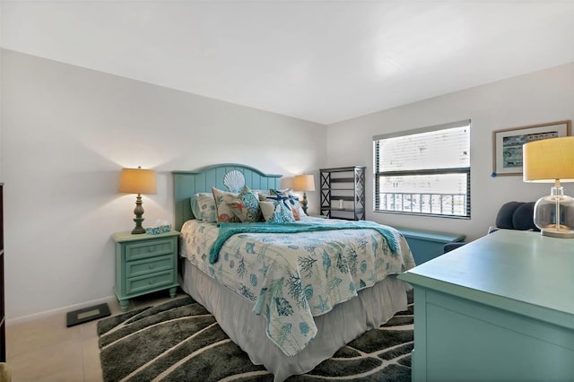 bedroom featuring baseboards and dark tile patterned flooring