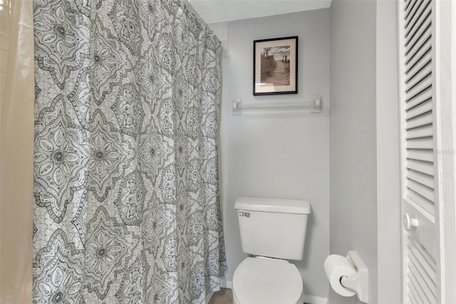 full bath featuring a shower with shower curtain and toilet